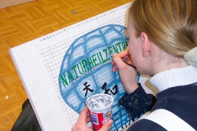 Anja Hesse legt den am Computer selbst entworfenen Schriftzug farblich aus. Vorher hat sie ihn der Ballon-Form angepasst, ausgedruckt und mit einem Gitternetz überzogen, mit dessen Hilfe sie ihn auf den Ballon auf der Platte übertragen hat. Wie man das macht, können Sie bei uns lernen!